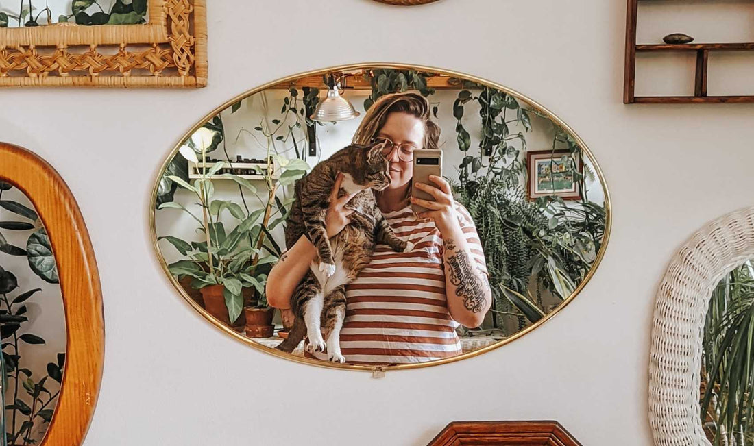 Stef and her tabby, Charles, surrounded by plants.