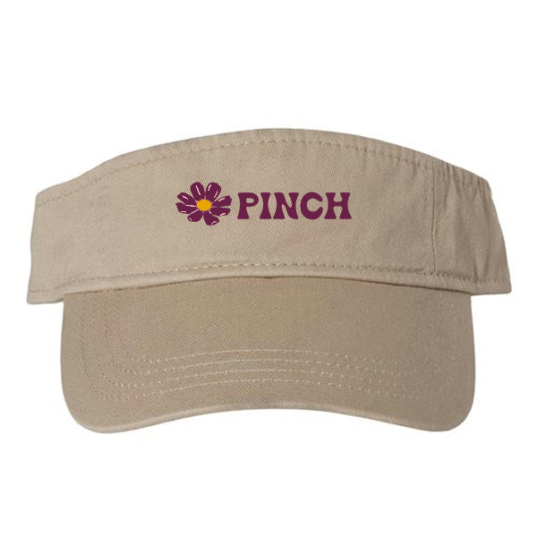 Beige visor with embroidered dark pink flowers and PINCH logo type, all on a white background.