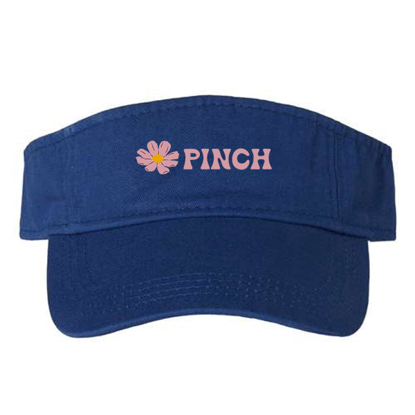 Royal blue visor with embroidered light pink flowers and PINCH logo type, all on a white background.